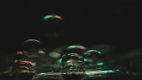 Beautiful colored bubbles in a liquid on a black background. Close-up. Slow Stock Footage 97847824