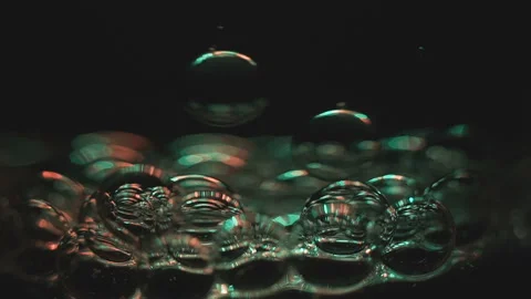 Beautiful colored bubbles in a liquid on a black background. Close-up. Slow Video stock 97847842