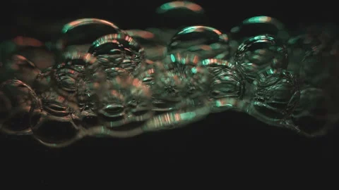 Beautiful colored bubbles in a liquid on a black background. Close-up. Slow Stock Footage 97847955