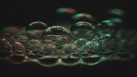 Beautiful colored bubbles in a liquid on a black background. Close-up. Slow Stock Footage 97848005