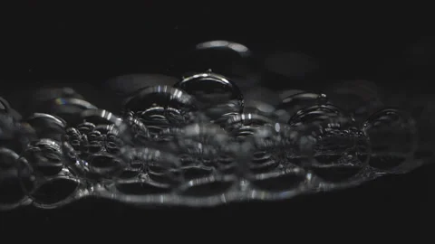 Beautiful colored bubbles in a liquid on a black background. Close-up. Slow Stock Footage 97848071