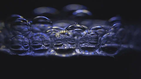 Beautiful colored bubbles in a liquid on a black background. Close-up. Slow Stock Footage 97849628