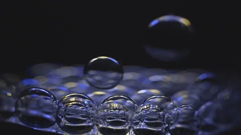 Beautiful colored bubbles in a liquid on a black background. Close-up. Slow 스톡 동영상 97849660