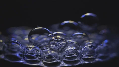 Beautiful colored bubbles in a liquid on a black background. Close-up. Slow Stock Footage 97849667