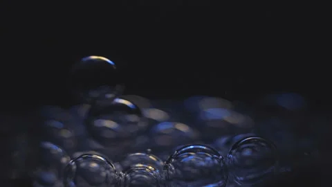 Beautiful colored bubbles in a liquid on a black background. Close-up. Slow Video stock 97849717