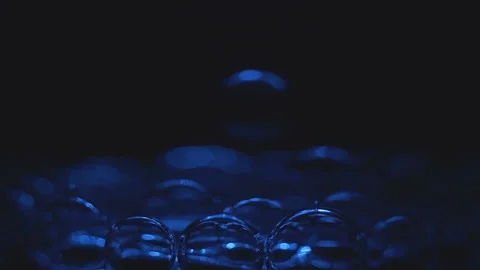 Beautiful colored bubbles in a liquid on a black background. Close-up. Slow Stock Footage 97849760