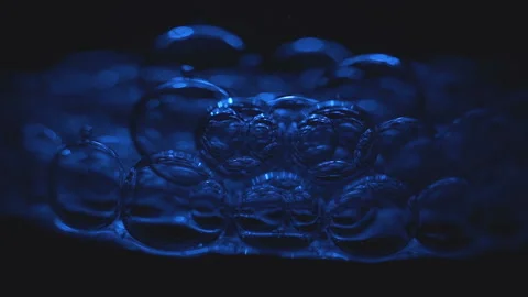 Beautiful colored bubbles in a liquid on a black background. Close-up. Slow Stock Footage 97849789