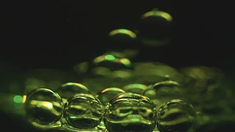 Beautiful colored bubbles in a liquid on a black background. Close-up. Slow Stock Footage 97849824