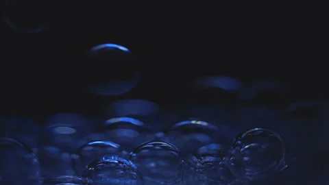 Beautiful colored bubbles in a liquid on a black background. Close-up. Slow Stock Footage 97849998