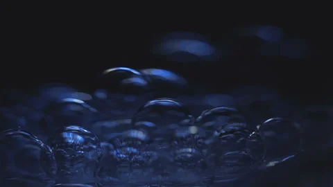 Beautiful colored bubbles in a liquid on a black background. Close-up. Slow Stock Footage 97850017