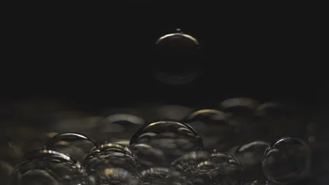 Beautiful colored bubbles in a liquid on a black background. Close-up. Slow Video stock 97850019