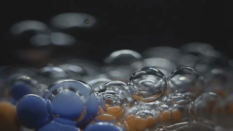 Beautiful colored bubbles in a liquid on a black background. Close-up. Slow Stock Footage 97852352