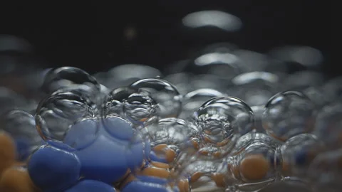 Beautiful colored bubbles in a liquid on a black background. Close-up. Slow Stock Footage 97852396