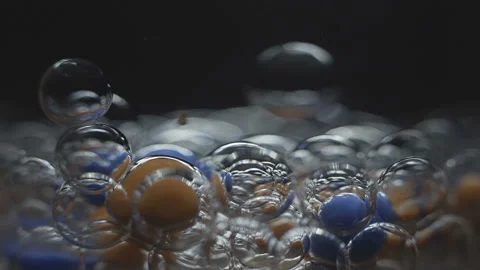 Beautiful colored bubbles in a liquid on a black background. Close-up. Slow Video stock 97852425