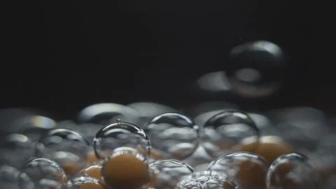 Beautiful colored bubbles in a liquid on a black background. Close-up. Slow Stock Footage 97852457