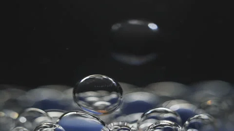 Beautiful colored bubbles in a liquid on a black background. Close-up. Slow Stock Footage 97852570