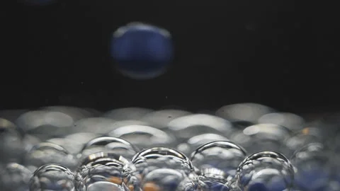 Beautiful colored bubbles in a liquid on a black background. Close-up. Slow Video stock 97852580