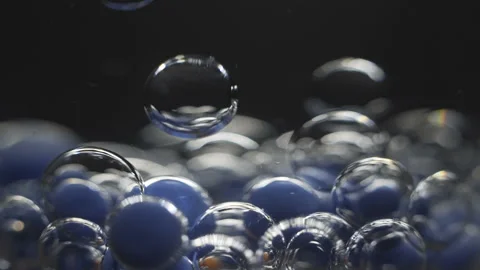 Beautiful colored bubbles in a liquid on a black background. Close-up. Slow Stock Footage 97852604