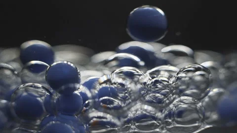 Beautiful colored bubbles in a liquid on a black background. Close-up. Slow Stock Footage 97852606