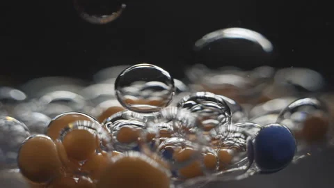 Beautiful colored bubbles in a liquid on a black background. Close-up. Slow Stock Footage 97852637