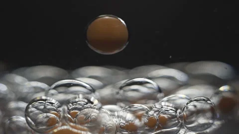 Beautiful colored bubbles in a liquid on a black background. Close-up. Slow Stock Footage 97852644