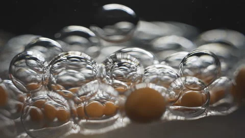 Beautiful colored bubbles in a liquid on a black background. Close-up. Slow Stock Footage 97852683