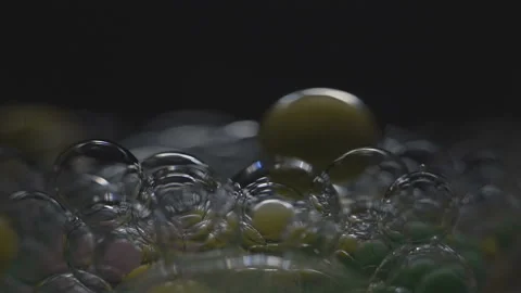 Beautiful colored bubbles in a liquid on a black background. Close-up. Slow 스톡 동영상 97852710