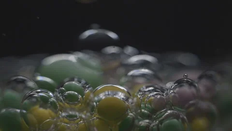 Beautiful colored bubbles in a liquid on a black background. Close-up. Slow Video stock 97852750