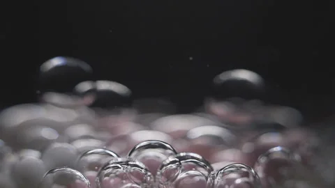 Beautiful colored bubbles in a liquid on a black background. Close-up. Slow Stock Footage 97852802