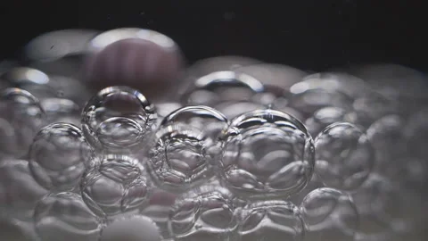 Beautiful colored bubbles in a liquid on a black background. Close-up. Slow Stock Footage 97852827