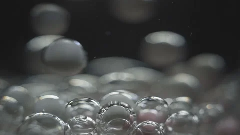 Beautiful colored bubbles in a liquid on a black background. Close-up. Slow Stock Footage 97852862