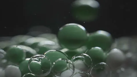 Beautiful colored bubbles in a liquid on a black background. Close-up. Slow Stock Footage 97852878