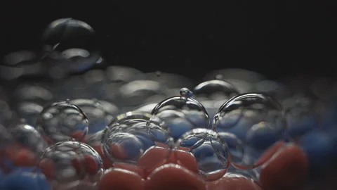Beautiful colored bubbles in a liquid on a black background. Close-up. Slow Video stock 97852908
