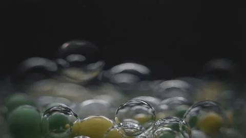 Beautiful colored bubbles in a liquid on a black background. Close-up. Slow 스톡 동영상 97852985