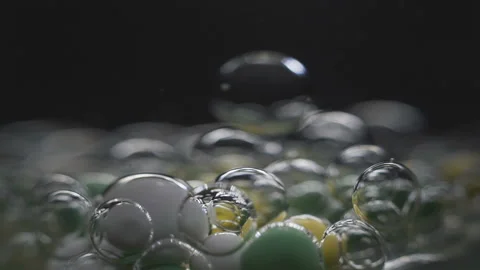 Beautiful colored bubbles in a liquid on a black background. Close-up. Slow Video stock 97853032