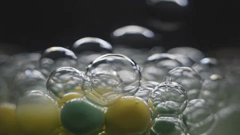 Beautiful colored bubbles in a liquid on a black background. Close-up. Slow Video stock 97853084