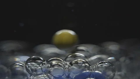Beautiful colored bubbles in a liquid on a black background. Close-up. Slow 스톡 동영상 97853196