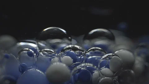 Beautiful colored bubbles in a liquid on a black background. Close-up. Slow Stock Footage 97853198