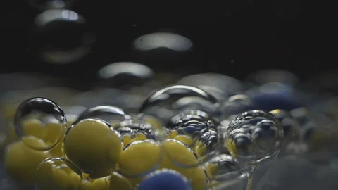Beautiful colored bubbles in a liquid on a black background. Close-up. Slow 스톡 동영상 97853254