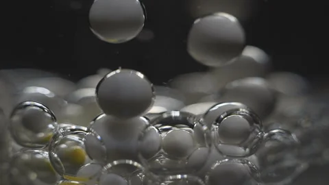 Beautiful colored bubbles in a liquid on a black background. Close-up. Slow Stock Footage 97853331