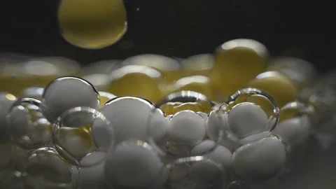 Beautiful colored bubbles in a liquid on a black background. Close-up. Slow Stock Footage 97853367