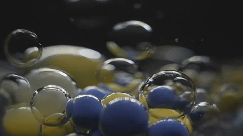 Beautiful colored bubbles in a liquid on a black background. Close-up. Slow Stock Footage 97853370