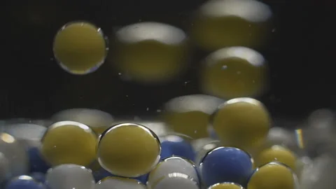 Beautiful colored bubbles in a liquid on a black background. Close-up. Slow Stock Footage 97853422