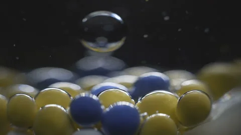 Beautiful colored bubbles in a liquid on a black background. Close-up. Slow Stock Footage 97853452