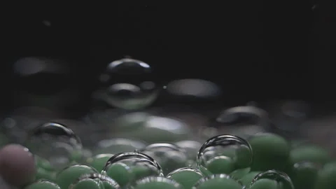 Beautiful colored bubbles in a liquid on a black background. Close-up. Slow Video stock 97853472