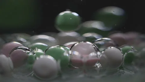 Beautiful colored bubbles in a liquid on a black background. Close-up. Slow 스톡 동영상 97853516