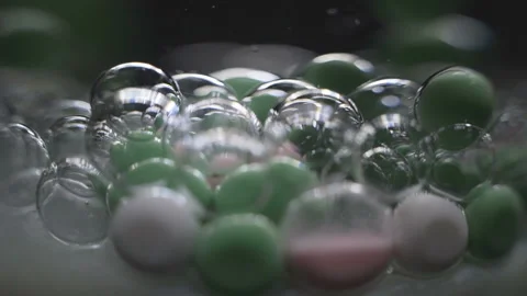 Beautiful colored bubbles in a liquid on a black background. Close-up. Slow Stock Footage 97853541