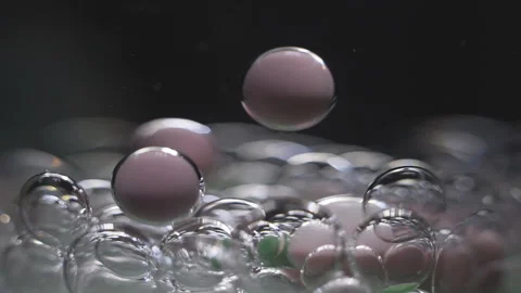 Beautiful colored bubbles in a liquid on a black background. Close-up. Slow Stock Footage 97853543