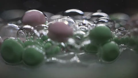Beautiful colored bubbles in a liquid on a black background. Close-up. Slow Stock Footage 97853577