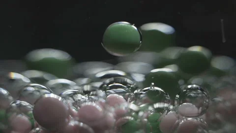 Beautiful colored bubbles in a liquid on a black background. Close-up. Slow Stock Footage 97853587